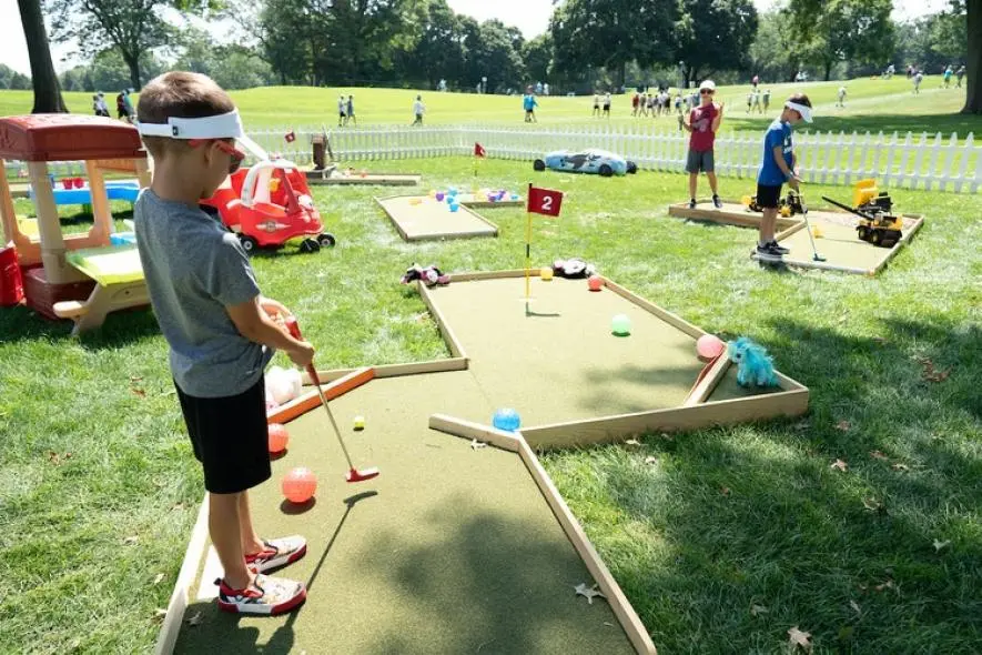 kid playing put put golf on a green at the Kaulig Championship